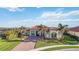 Beautiful home with a well-manicured lawn, brick driveway, and lush tropical landscaping at 10705 Tarflower Dr, Venice, FL 34293