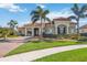 Beautiful home featuring a landscaped front yard, palm trees, and a brick driveway at 10705 Tarflower Dr, Venice, FL 34293