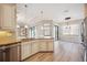 Open kitchen with stainless steel appliances, an island with a sink, and wood flooring at 10705 Tarflower Dr, Venice, FL 34293