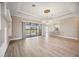 Living room featuring wood floors, a modern chandelier, and access to the lanai at 10705 Tarflower Dr, Venice, FL 34293
