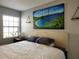 King-size bed in a spacious bedroom with large windows and artwork at 13100 S Mccall Rd # 110, Port Charlotte, FL 33981