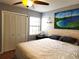 King-size bed in a spacious bedroom with large windows and artwork at 13100 S Mccall Rd # 110, Port Charlotte, FL 33981