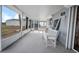 Screened porch with white bench overlooking yard at 1471 Deer Creek Dr, Englewood, FL 34223