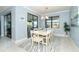 Bright dining room with white table and chairs, view to backyard, and stylish rug at 1506 Hyssop Loop, North Port, FL 34289