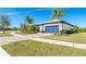 House exterior showcasing a paver driveway, landscaping, and a blue garage door at 1506 Hyssop Loop, North Port, FL 34289