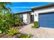 Front entry with brick walkway and nicely landscaped tropical plants at 1506 Hyssop Loop, North Port, FL 34289