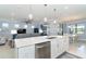 Open kitchen with a large island, white cabinets, and stainless steel dishwasher at 1506 Hyssop Loop, North Port, FL 34289
