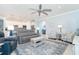 Spacious living area featuring a gray sofa and armchairs, coffee table and a view to the kitchen at 1506 Hyssop Loop, North Port, FL 34289