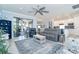 Bright living room with comfy seating, large windows, and a view to the kitchen at 1506 Hyssop Loop, North Port, FL 34289