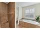 Bathroom featuring a walk-in shower, soaking tub, and updated fixtures at 15228 Chinook Way, Port Charlotte, FL 33981