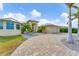Front view of a house with a paved driveway, landscaping, and palm trees at 15228 Chinook Way, Port Charlotte, FL 33981
