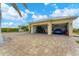 Home's exterior showcasing a paver driveway and two-car garage at 15228 Chinook Way, Port Charlotte, FL 33981