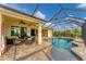 Covered patio with wicker furniture adjacent to a refreshing freeform pool at 15228 Chinook Way, Port Charlotte, FL 33981