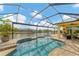 Relaxing pool and patio area with a screened enclosure, offering water views at 15228 Chinook Way, Port Charlotte, FL 33981
