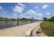 Serene waterfront pathway with a bench overlooking the calm water at 15228 Chinook Way, Port Charlotte, FL 33981