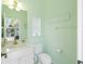 Small bathroom with light green walls, white vanity, and toilet at 15626 Meacham Cir, Port Charlotte, FL 33981