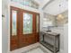 Elegant entryway with a wooden door, stained glass, and a console table at 15626 Meacham Cir, Port Charlotte, FL 33981