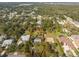Aerial view of a single-Gathering home with a pool, surrounded by lush landscaping and other houses at 1651 Maria St, Englewood, FL 34223