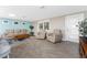 Bright living room with light beige recliners, wood-look tile floors, and a large window at 1651 Maria St, Englewood, FL 34223