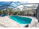 Inviting pool area with covered patio, comfortable seating, and a large screened enclosure at 1651 Maria St, Englewood, FL 34223