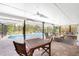Spacious covered patio with pool view, wooden dining set, and comfortable seating at 1651 Maria St, Englewood, FL 34223