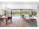 Covered patio with wooden table and chairs, comfortable seating area, and pool view at 1651 Maria St, Englewood, FL 34223