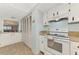 Bright kitchen features white appliances and light countertops at 1730 Manasota Beach Rd # 110, Englewood, FL 34223