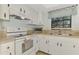 Clean kitchen featuring white cabinets and appliances at 1730 Manasota Beach Rd # 110, Englewood, FL 34223