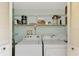 Convenient laundry closet with washer, dryer, and shelving at 1730 Manasota Beach Rd # 110, Englewood, FL 34223