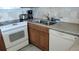 Granite countertop kitchen with double sink and dishwasher at 1760 Gulf Blvd # 511, Englewood, FL 34223