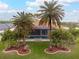 Stunning backyard oasis with a sparkling pool, lush landscaping, and mature palm trees at 185 Rotonda E Blvd, Rotonda West, FL 33947