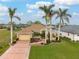 Single-story home with a two-car garage, attractive landscaping, and palm trees at 185 Rotonda E Blvd, Rotonda West, FL 33947