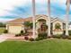 Single-story home with a covered entryway, palm trees, and well manicured lawn at 185 Rotonda E Blvd, Rotonda West, FL 33947