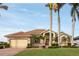 Tan house with a brown door and a three-car garage at 185 Rotonda E Blvd, Rotonda West, FL 33947