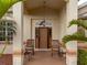 Front door entry with rocking chairs and a covered porch at 185 Rotonda E Blvd, Rotonda West, FL 33947