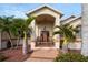 Front porch with two rocking chairs, featuring a covered entryway and tropical landscaping at 185 Rotonda E Blvd, Rotonda West, FL 33947