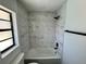 Updated bathroom with marble tile and a bathtub at 19782 Midway Blvd, Port Charlotte, FL 33948