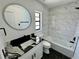 Modern bathroom with white vanity, marble tile, and black fixtures at 19782 Midway Blvd, Port Charlotte, FL 33948