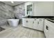 Spa-like bathroom featuring a freestanding tub and gray tile at 19782 Midway Blvd, Port Charlotte, FL 33948