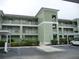 Green two-story condo building with parking and landscaping at 2121 Heron Lake Dr # 301, Punta Gorda, FL 33983