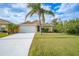 Tan house with two-car garage and palm tree at 215 Australian Dr, Rotonda West, FL 33947