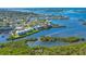 Stunning aerial view of waterfront condo complex with boat docks and lush landscaping on the water at 2424 Placida Rd # C101, Englewood, FL 34224