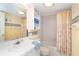 Bathroom with floral shower curtain, white vanity, and bathtub at 2424 Placida Rd # C101, Englewood, FL 34224