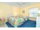 Bedroom with two twin beds, blue carpet, and yellow walls at 2424 Placida Rd # C101, Englewood, FL 34224