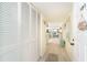 Long entry hall with built-in storage and view into the living room at 2424 Placida Rd # C101, Englewood, FL 34224