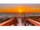 A boardwalk gives access to the sandy beach with the sunset over the Gulf of Mexico at 2450 N Beach Rd # 113, Englewood, FL 34223