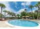 Large community pool with seating and lounge area with barbecue grills and lush tropical landscaping throughout at 2450 N Beach Rd # 113, Englewood, FL 34223