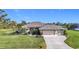House exterior showcasing a two-car garage and well-manicured lawn at 252 Medalist Rd, Rotonda West, FL 33947