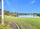 Peaceful backyard oasis with lush lawn and serene lake view at 252 Medalist Rd, Rotonda West, FL 33947