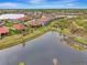 Aerial view of a community with houses, ponds, and lush greenery at 26906 Weiskopf Dr, Englewood, FL 34223